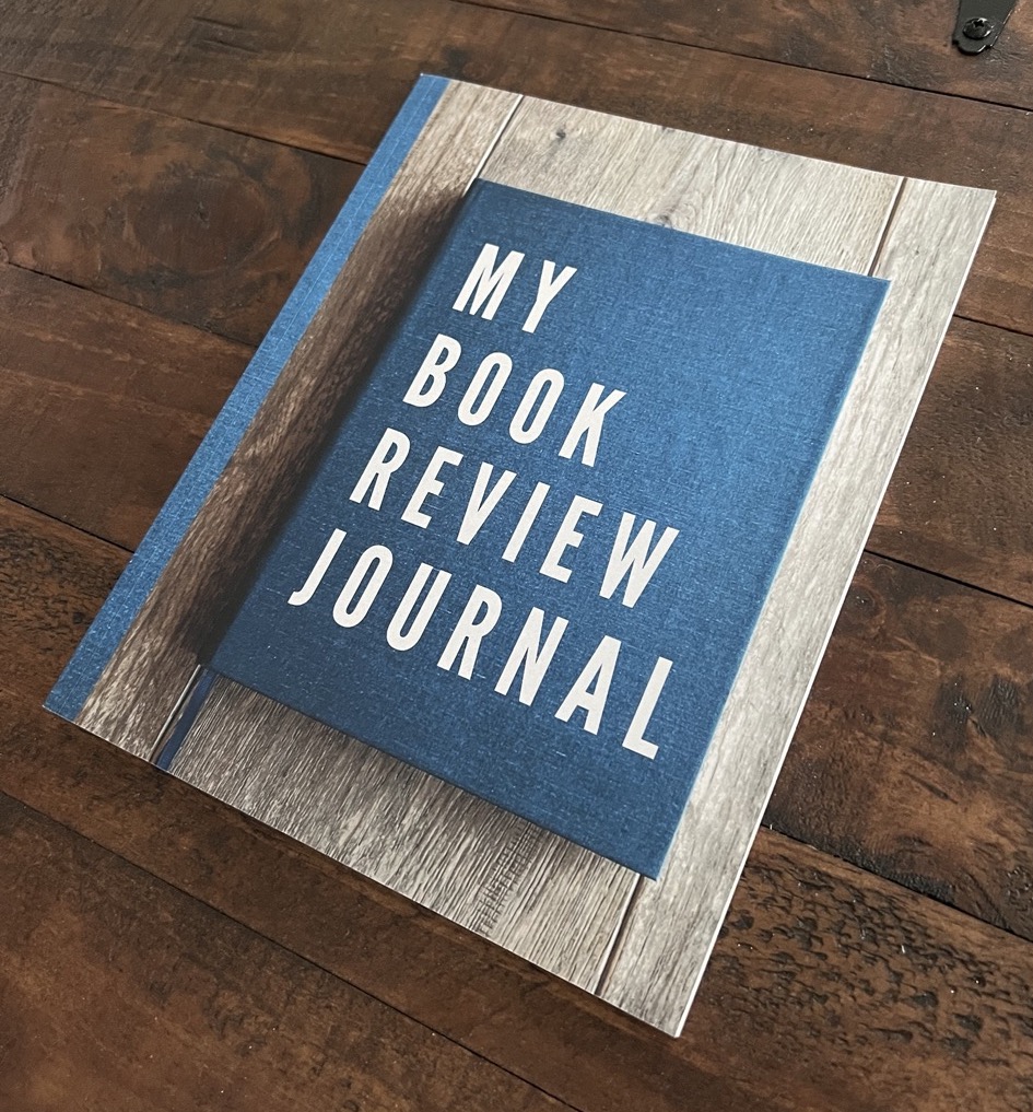 my Book Review Journal lying on a dark wooden coffee table