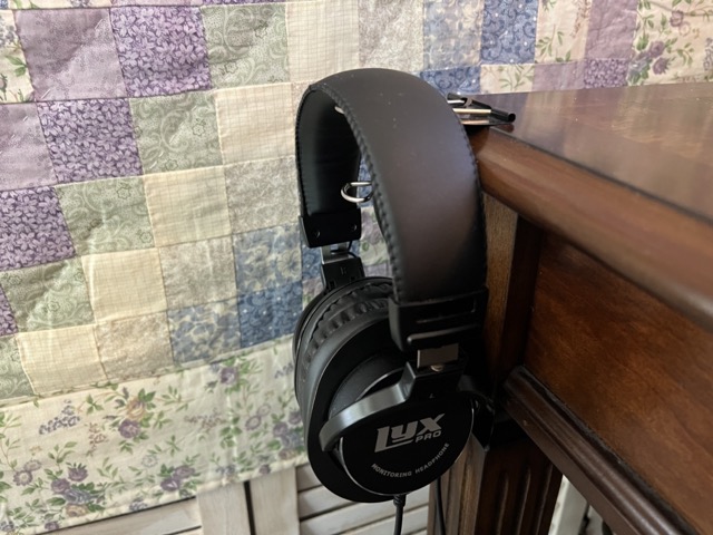 Headphones resting on big metal clip on table edge